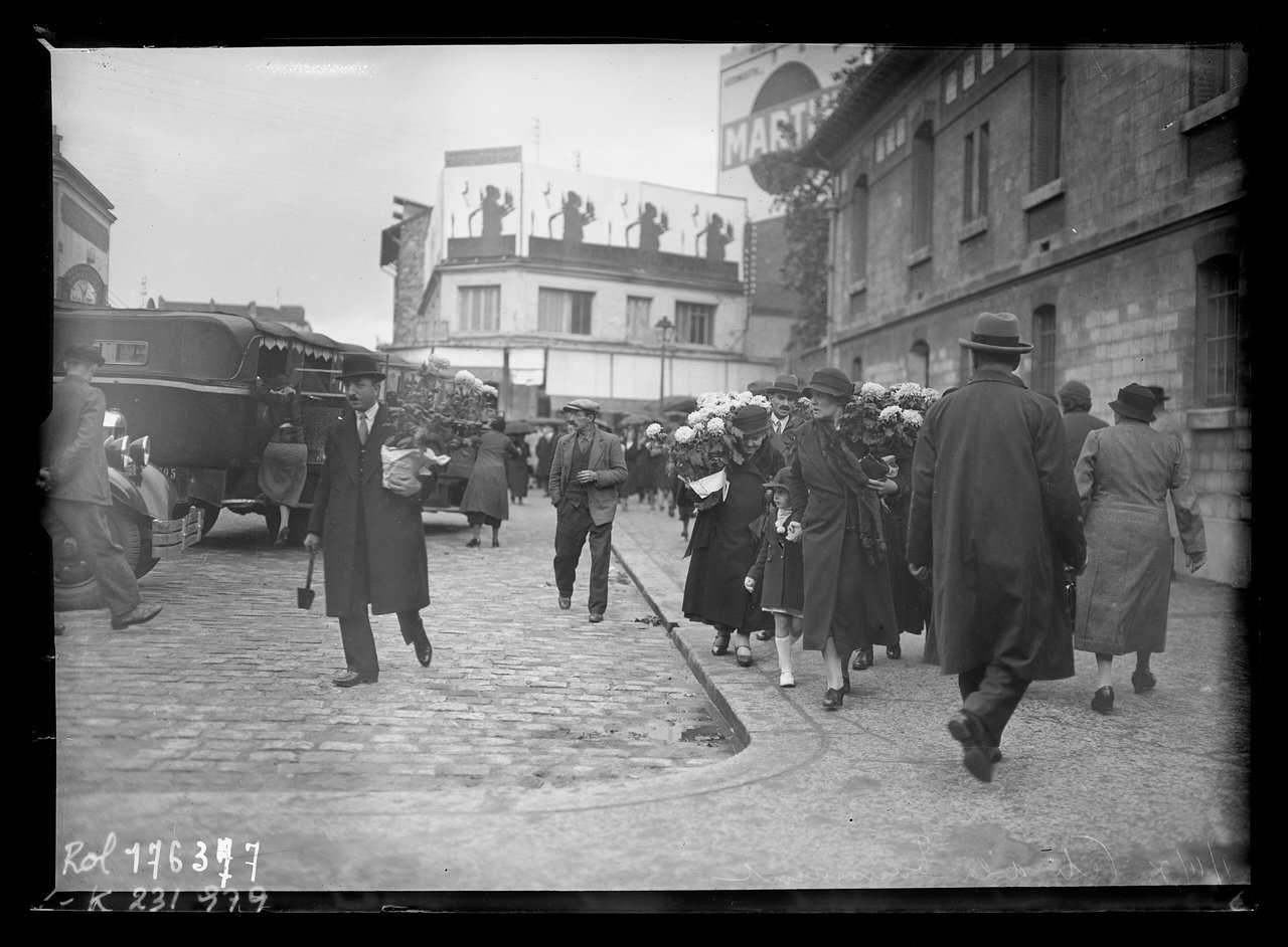 1er novembre 1933 à Paris : foule se rendant au cimetière avec des pots de chrysanthèmes pour la Toussaint, quatorze ans après l'appel de Poincaré de 1919, le rite est ancré.